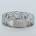 Hand-engraved platinum band with three round diamonds set in low-profile bezels.